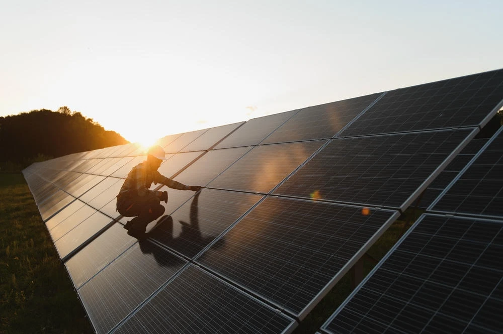 Installer checking solar panels at sunset