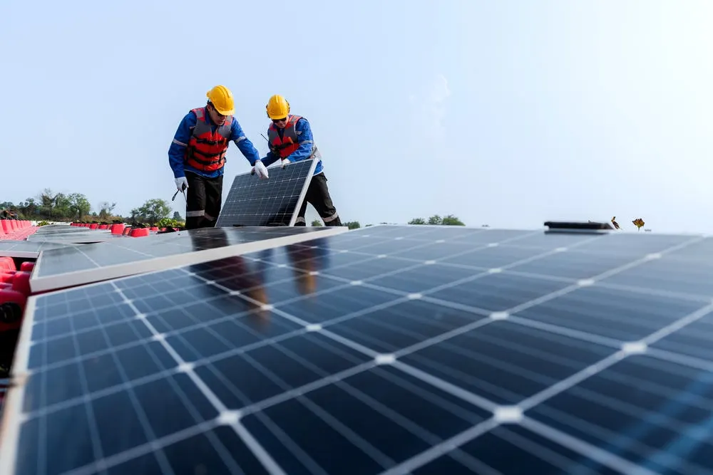 Installers fitting panels on a commercial array