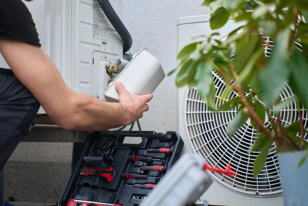 Technician servicing an air conditioning outdoor unit